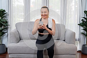 Senior woman taking break after home workout and talking on the phone. Clout