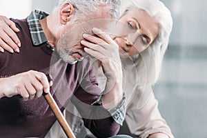 Senior woman taking care of husband with strong headache