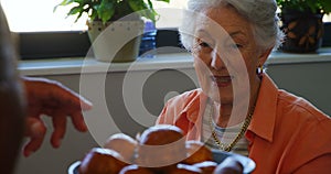 Senior woman taking cupcake from tray 4k