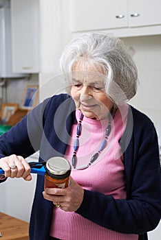 Senior Woman Taking Lid Off Jar With Kitchen Aid