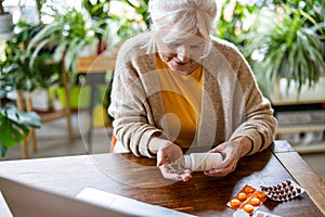 Senior woman taking pills from a bottle