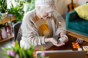 Senior woman taking pills from a bottle