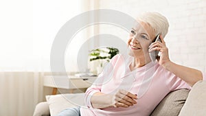 Senior woman talking on her mobile phone at home