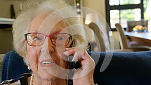 Senior woman talking on mobile phone in living room