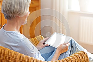 Senior woman talking tablet computer home