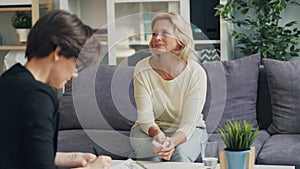 Senior woman talking to therapist discussing problems in modern office