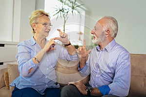 Senior woman talking using sign language with her hearing impairment man