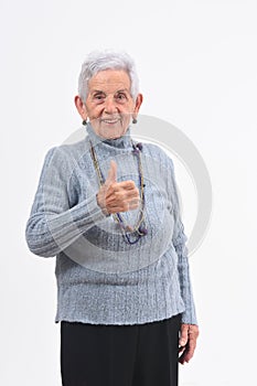 Senior woman thumps up on white background