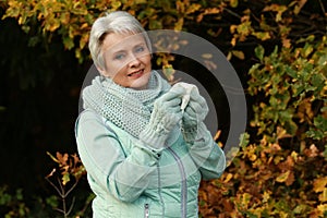 Senior woman with tissue blowing her nose