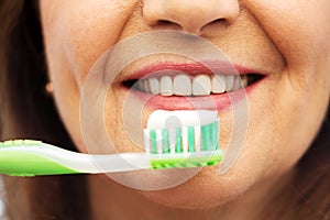 Senior woman with toothbrush brushing her teeth