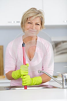 senior woman unblocking sink