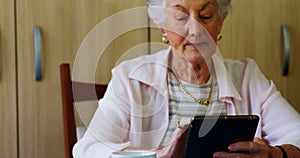 Senior woman using digital tablet at table 4k