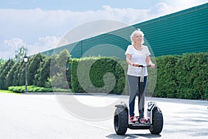 Senior woman using electric personal transporter