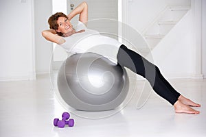 Senior woman using gym ball