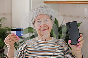 Senior woman using her credit card to shop online