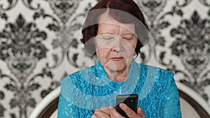 Senior woman using her mobile phone at home.