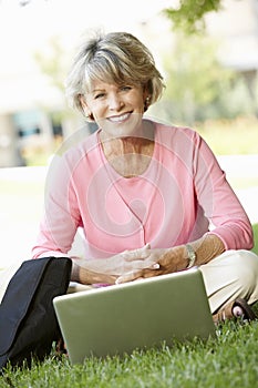 Senior woman using laptop outdoors