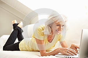 Senior Woman Using Laptop Relaxing Sitting On Sofa