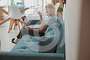 Senior woman using laptop while sitting at home