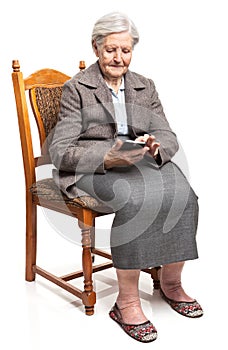 Senior woman using mobile phone sitting on chair