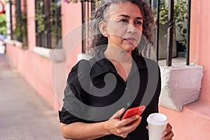 Senior Woman Using Mobile Phone In The Street