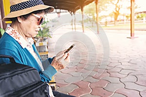 Senior woman using a mobile phone in train station