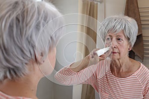 Senior woman using a nasal spray