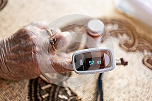 Senior woman using pulse oximeter photo