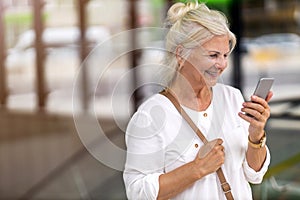 Senior woman using smartphone in the city