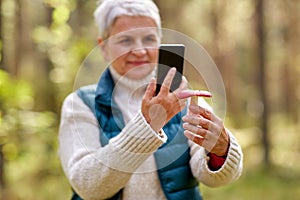 senior woman using smartphone to identify mushroom