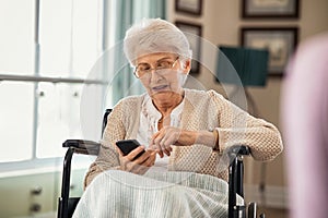 Senior woman using smartphone on wheelchair