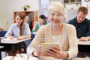 Senior woman using tablet computer at adult education class photo