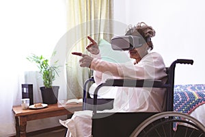 Senior woman using virtual realty headset at nursing home