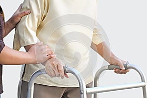 Senior woman using a walker with caregiver