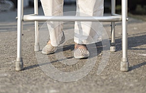 Senior woman using a walker cross street.
