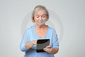 Senior woman using a wireless black tablet PC