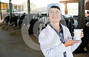 Senior woman veterinarian with milk on dairy farm