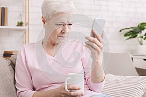 Senior woman with vision problems using phone