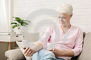 Senior woman with vision problems using phone