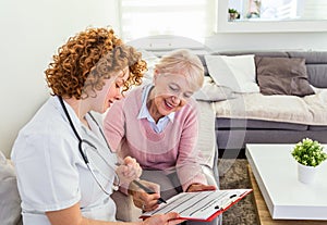Senior woman is visited by her doctor or caregiver. Female doctor or nurse talking with senior patient. Medicine, age, health care