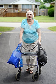 Senior woman and walker overloaded with shopping bags photo