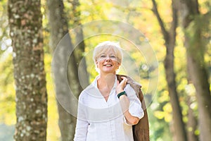 Senior woman walking in autumn forest