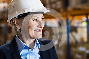 Senior woman warehouse manager or supervisor with white helmet.