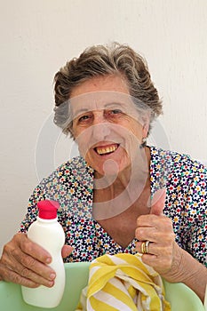 A senior woman is washing cloths by hand