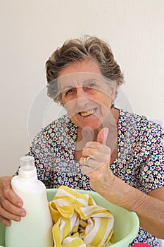 A senior woman is washing cloths by hand