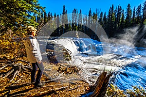 Senior woman watching the Murtle River as it tumbles over the cusp of Dawson Falls in Wells Gray Provincial Park photo