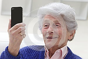 Senior woman watching something to her mobile phone