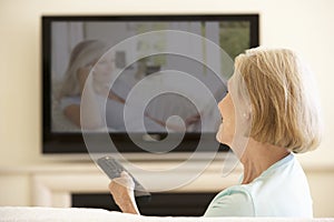 Senior Woman Watching Widescreen TV At Home photo