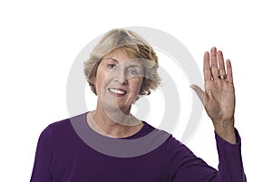 Senior woman waving hand in greeting photo