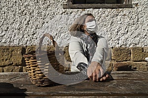 A senior woman, wearing face mask, stretches her arms, Spain